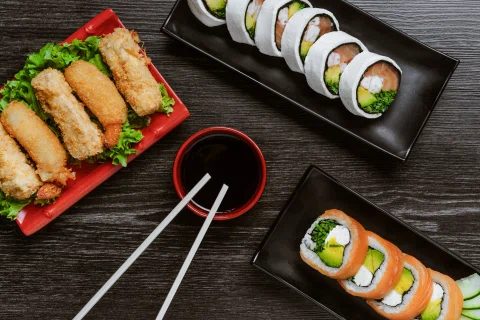 Selección de sushi y empanizados con salsa de soya.
