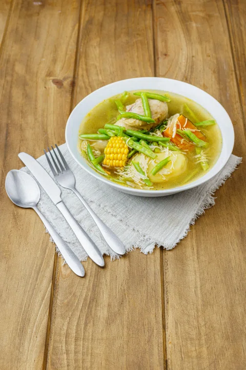 Sopa de vegetales servida en bowl blanco.
