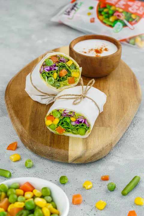 Wraps de vegetales presentados sobre una tabla de madera.
