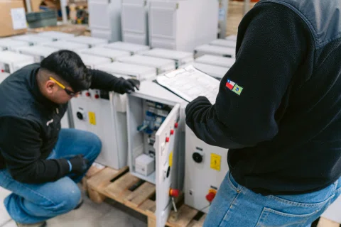 Técnicos instalando o revisando gabinetes eléctricos.
