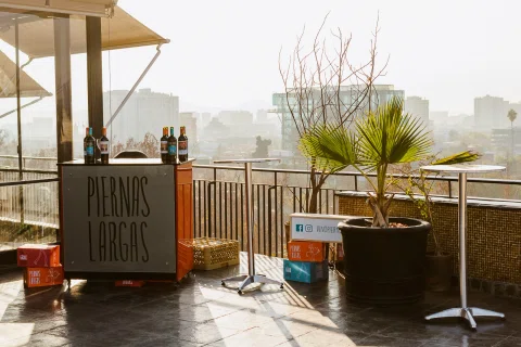 Terraza preparada para un evento con barra y vista de la ciudad.