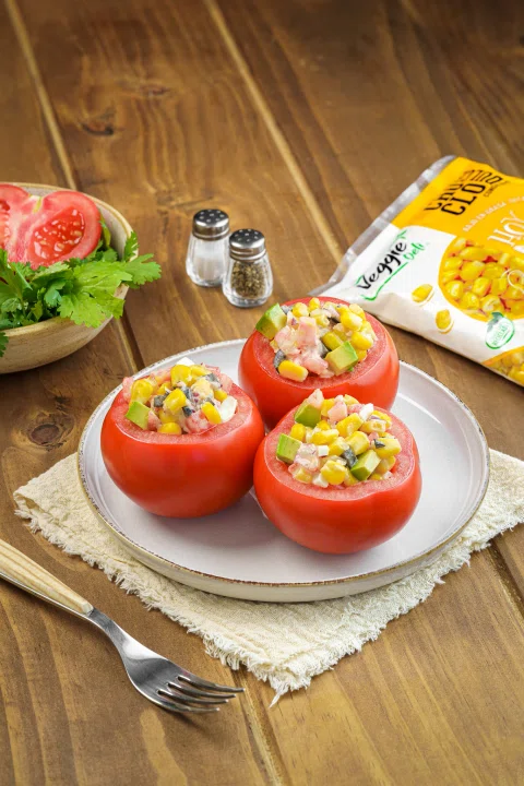 Tomates rellenos servidos sobre plato blanco.