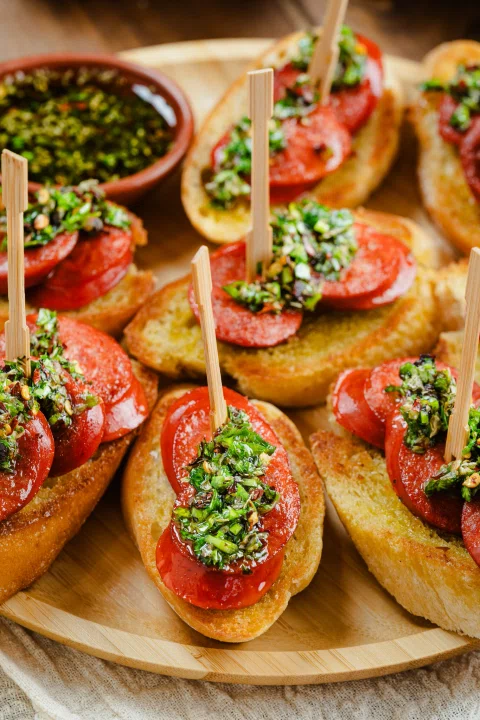 Tostadas con salchichas vegetales tomate y hojas verdes.
