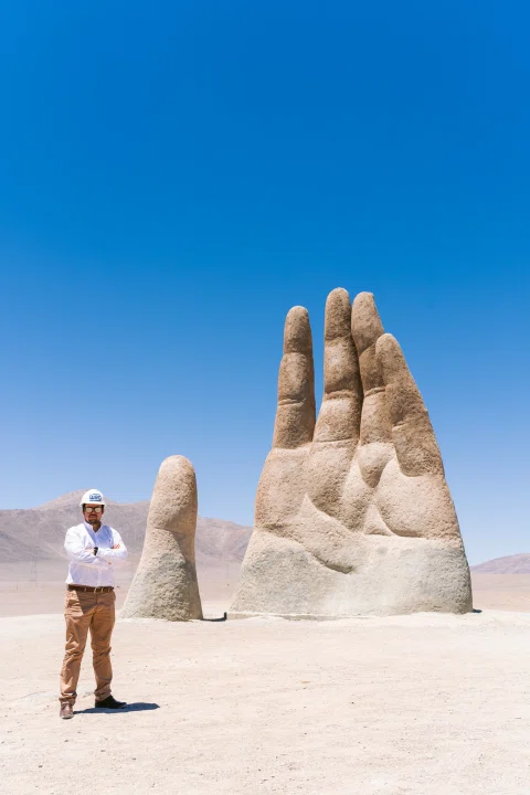 Trabajador junto a escultura Mano del Desierto.