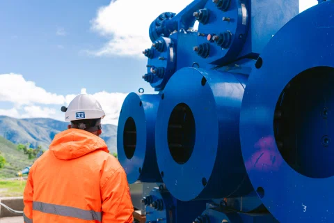 Trabajador frente a gran equipo azul industrial.