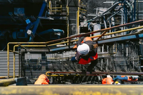 Trabajador realizando tarea en estructura de planta.