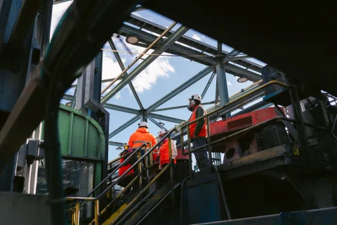 Trabajadores realizan mantenimiento en una estructura industrial elevada.