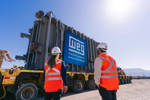 Trabajadores WEG junto a transformador en transporte.