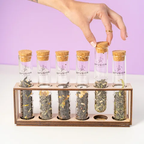 Tubos de hierbas e infusiones en soporte de madera.