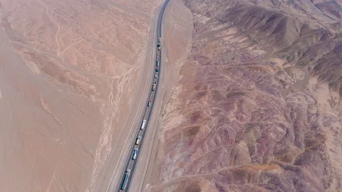 Vista aérea de convoy industrial en carretera del desierto.