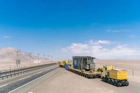 Vista aérea oblicua de convoy con transformador en carretera.